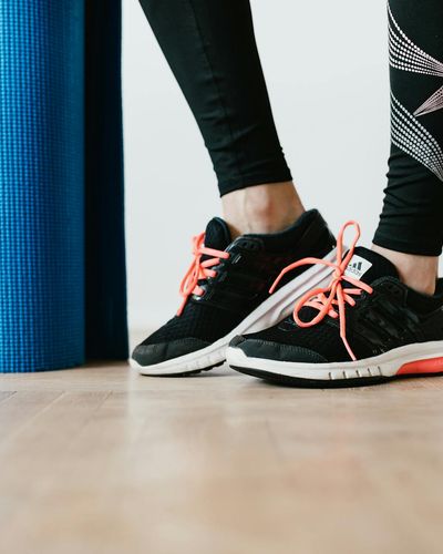 Close-up on athletic shoes and a mat, symbolizing readiness for practice.